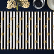 Load image into Gallery viewer, Elegant black and white striped placemat adorned with gold snowflakes and glitter like details.