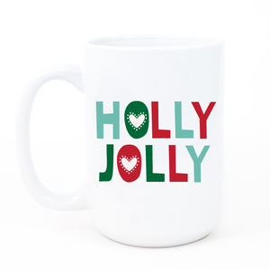 A white ceramic coffee mug with the vibrant, bold words HOLLY JOLLY printed in hues of red and green in a modern, trendy, fun, and festive font.