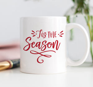 Tis the Season Coffee Mug by Digibuddha, featuring 'tis the season written in red festive script on a white glossy ceramic mug.