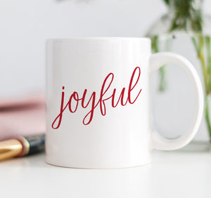 A Joyful Christmas coffee mug with festive, red, modern, minimalist letters printed on fine white ceramic. Ideal holiday gift mug.