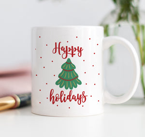 A festive Happy Holidays coffee mug featuring a vibrant Christmas tree graphic and bold red lettering, perfect for the holiday season.