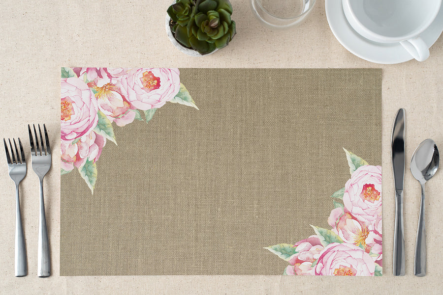 Pink vintage floral paper placemats, featuring rose design and burlap look, ideal for rustic dining and special events.