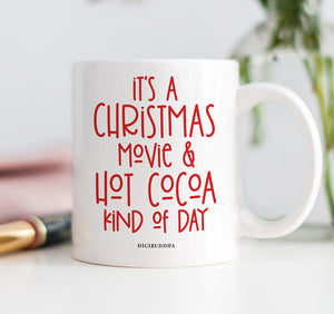 Red, playful and festive text "It's a Christmas movie & hot cocoa kind of day" on a white ceramic coffee mug by Digibuddha.
